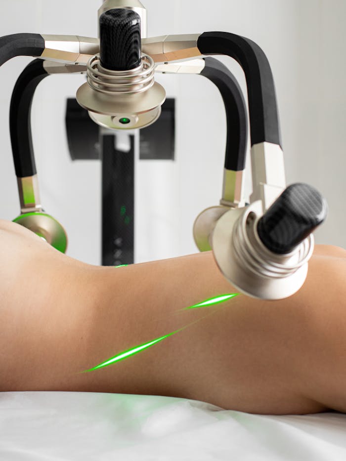 Crafting Captivating Headlines: Your awesome post title goes here Crop anonymous topless female patient lying under green lasers of modern fat loss machine with heads in light medical clinic